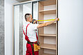 man measures shelves for a closet installation 2026 09 23 00 34 26 utc